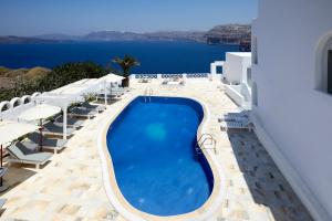 een zwembad met stoelen en uitzicht op de oceaan bij Santorini View in Akrotiri