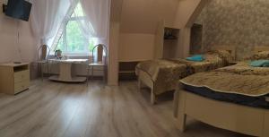 1 dormitorio con 2 camas, lavabo y ventana en Guest House Na Lesnoy, en Myshkin