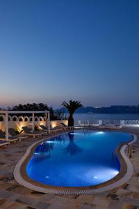 a swimming pool at night with a view of the water at Santorini View in Akrotiri