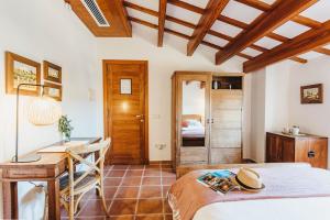 a bedroom with a bed and a desk and a table at Son Granot Hotel Rural & Restaurant in Es Castell