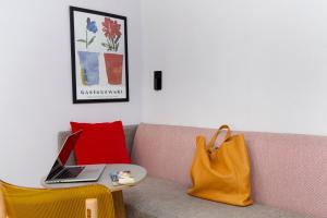 a couch with a laptop on a table and a bag at Hôtel De La Paix in Paris