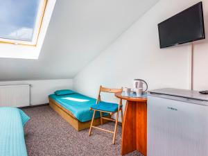 mały pokój z łóżkiem i stołem z krzesłem w obiekcie Orion Dom Gościnny w Dziwnowie
