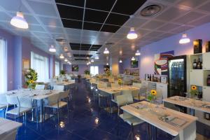 a dining room with white tables and chairs at Aurea Hotel in Tortoreto Lido