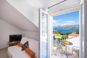 a room with a balcony with a view of the ocean at Castelletto in Cavtat