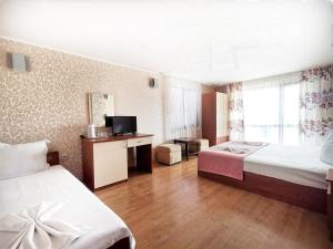 a hotel room with two beds and a television at Villa Mirage in Sozopol