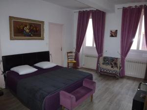 1 dormitorio con 1 cama de color púrpura y 1 silla en Le 18 by Benson, en Bollène