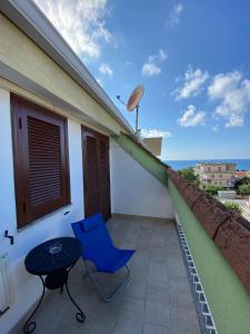 einen Balkon mit einem blauen Stuhl und einem Tisch in der Unterkunft A 300 passi dal mare in Tropea