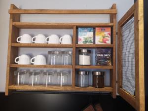 a wooden shelf with cups and jars on it at Chic Boutique Apart in Sinaia