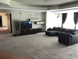 a living room with a couch and a flat screen tv at Hotel Florida Mamaia in Mamaia