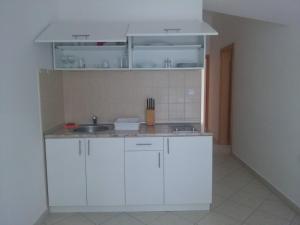 a kitchen with white cabinets and a sink at Luxury Villas Marko in Tivat