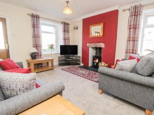 a living room with two couches and a fire place at Yewbarrow in Seascale