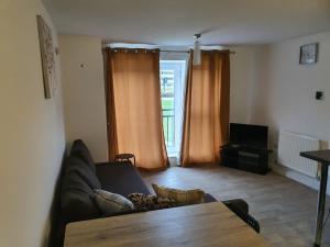 a living room with a couch and a table at Vetrelax Basildon Blake Apartment in Basildon