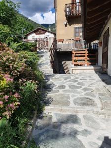 a stone walkway next to a building with a bench at Mansarda bilocale centro Brusson in Brusson