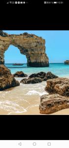 Une arche dans les rochers sur une plage avec l'océan dans l'établissement Casa do carmo N 10, à Olhão