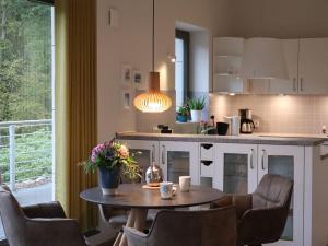 cocina con mesa, sillas y barra en Ferienwohnungen Seerose, en Bad Zwischenahn