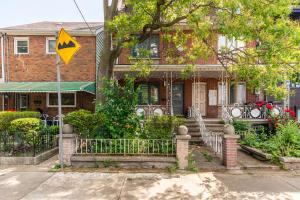 a house with a yellow street sign in front of it at Fancy Downtown House with HOT TUB & BBQ by GLOBALSTAY in Toronto