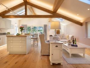 a kitchen and living room with a table and a couch at Twitchers Cottage in Kendal