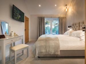 a bedroom with a bed and a desk and a window at Kirkstone in Kendal