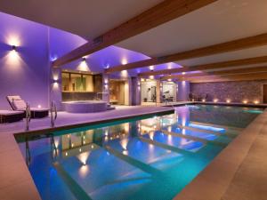 an indoor swimming pool in a house with purple lighting at Twitchers Cottage in Kendal