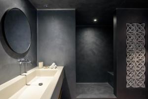 bagno con lavandino bianco e specchio di Este Luxury Suites a Firà