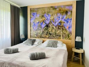 2 camas en un dormitorio con una pintura de flores púrpuras en Willa Leśna, en Zakopane