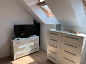 a bedroom with a dresser with a tv on it at Sylina Spa avec Jacuzzi Privé in Villeblevin