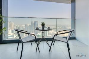 a table and two chairs in front of a window at Captivating 1BR at The Address Residences in JBR by Deluxe Holiday Homes in Dubai