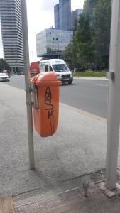 an orange trash can sitting on the side of a street at Mostly Muse in Eidenberg