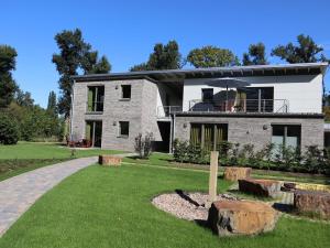 a large white brick house with a porch at Ferienwohnungen Seerose in Bad Zwischenahn