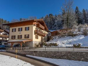 a house in the snow next to a road at Ferienwohnung Watzmannblick Maria Gern in Berchtesgaden