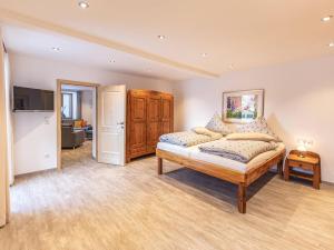 a large bedroom with a bed and a television at Ferienwohnung Watzmannblick Maria Gern in Berchtesgaden