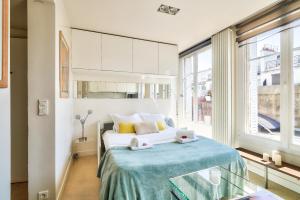 een slaapkamer met een bed en een groot raam bij Designed Studio with AC-Terrasse Vue Tour Eiffel in Parijs