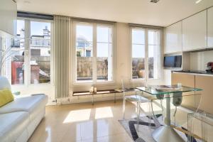 een woonkamer met een bank en een tafel bij Designed Studio with AC-Terrasse Vue Tour Eiffel in Parijs