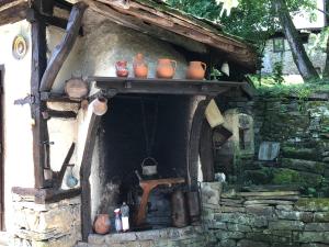 un horno de piedra con ollas encima en Etnographic Houses, en Dŭlbok Dol