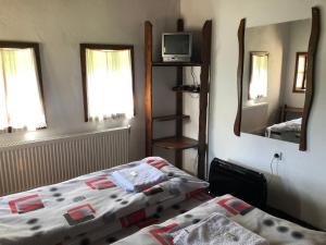 1 dormitorio con 2 camas y espejo en Etnographic Houses, en Dŭlbok Dol