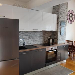 a kitchen with stainless steel appliances and white cabinets at Apartmani Mira Brela in Brela