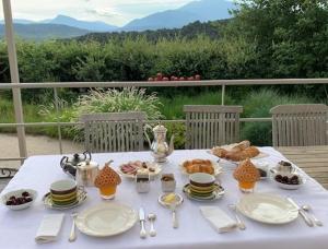 una mesa blanca con platos y comida. en L 'Havéli, en Vaison-la-Romaine
