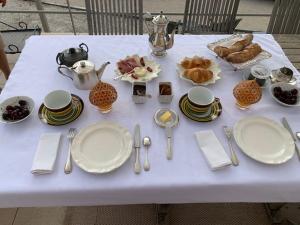 una mesa blanca con platos y utensilios. en L 'Havéli, en Vaison-la-Romaine