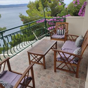 a patio with chairs and tables and a view of the water at Apartmani Mira Brela in Brela