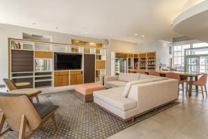 a living room with a couch and a tv at Holiday Inn Atlanta-Gas South Arena Area, an IHG Hotel in Duluth