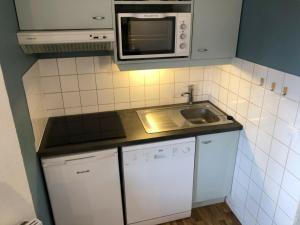 eine kleine Küche mit einer Spüle und einer Mikrowelle in der Unterkunft Appartement La Tania, 3 pièces, 6 personnes - FR-1-513-18 in La Tania
