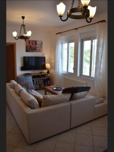 a living room with a couch and a tv at Villa Karin , with beautiful seaview! in Georgioupoli
