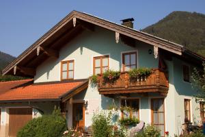 una casa con balcone fiorito di Ferienwohnung Anner a Aschau im Chiemgau