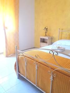 1 dormitorio con 1 cama con pared amarilla en Il sole, en Maruggio