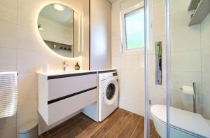a bathroom with a washing machine and a mirror at Residence Vrbnik in Vrbnik +15 photos
