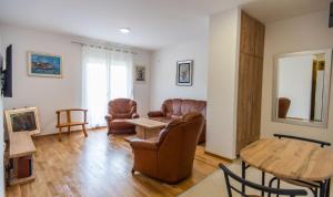 a living room with leather chairs and a table at Sunny Hill Suite Ljubovic in Podgorica