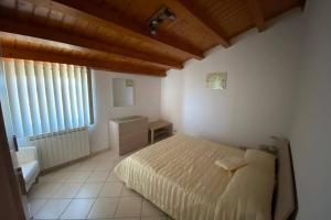 een slaapkamer met een bed, een bureau en een raam bij Loft incantevole con idromassaggio esterno privato in Patti