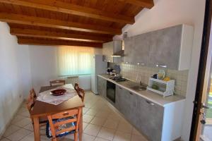 een keuken met een tafel en een kleine tafel en een tafel en een keuken met bij Loft incantevole con idromassaggio esterno privato in Patti
