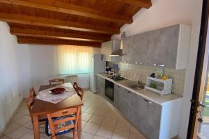 a kitchen with a table and a small table and a table and a kitchen with at Loft incantevole con idromassaggio esterno privato in Patti