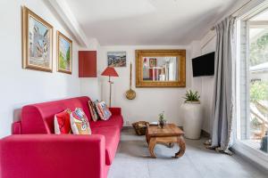 ein Wohnzimmer mit einem roten Sofa und einem Tisch in der Unterkunft Le Parc in Carpentras